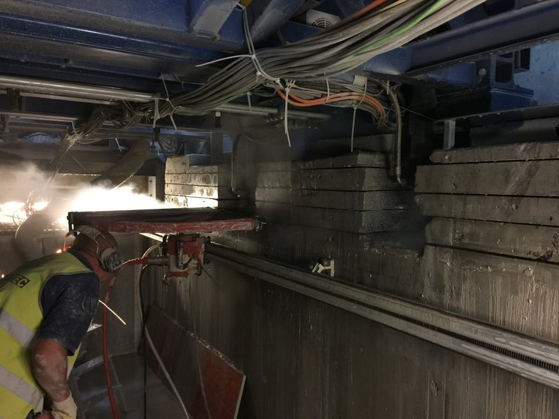 Mitarbeiter bei nassen Betonschneidarbeiten mit Bohrschlamm